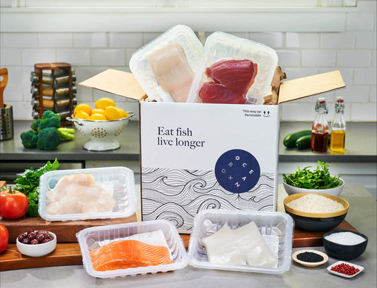 OceanBox Luxury Seafood Box with Chilean sea bass, yellowfin tuna, king salmon, halibut and dry sea scallops surrounded by fresh herbs and ingredients-Oceanbox