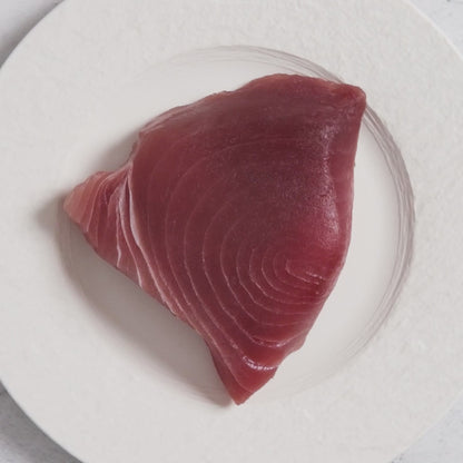 Close-up video of a fresh, deep-red wild-caught tuna steak being prepared, showcasing Oceanbox premium quality.